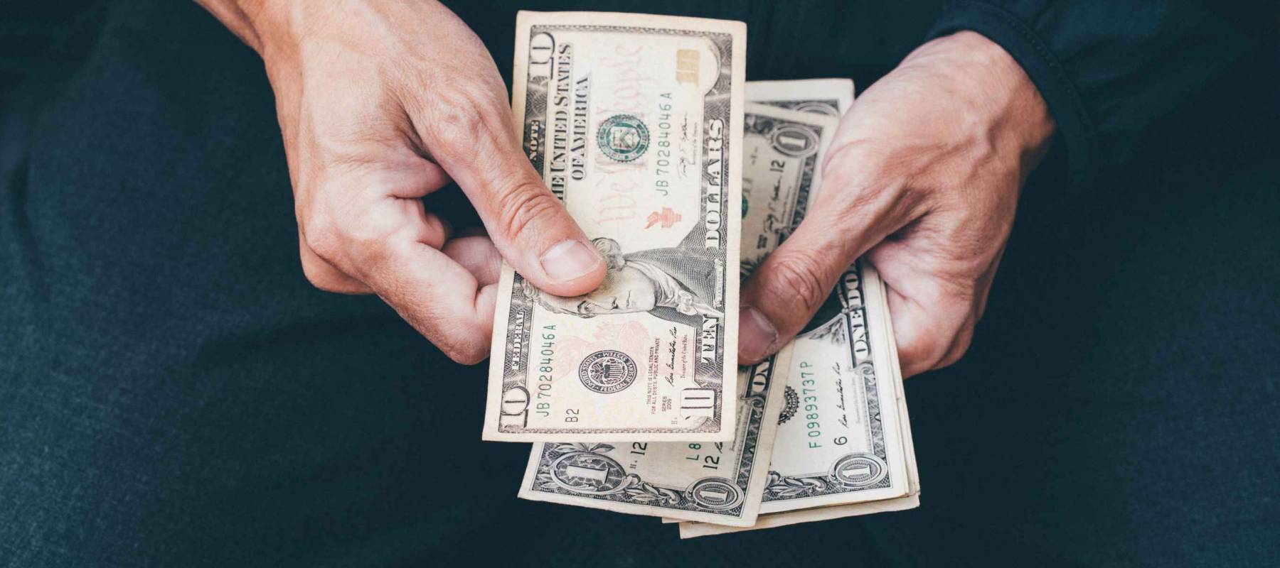 Close up of poor man hand with small money