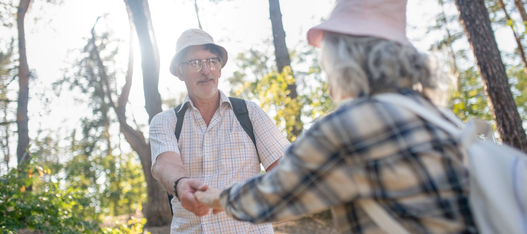 Husband holding hands of wife while walking in park