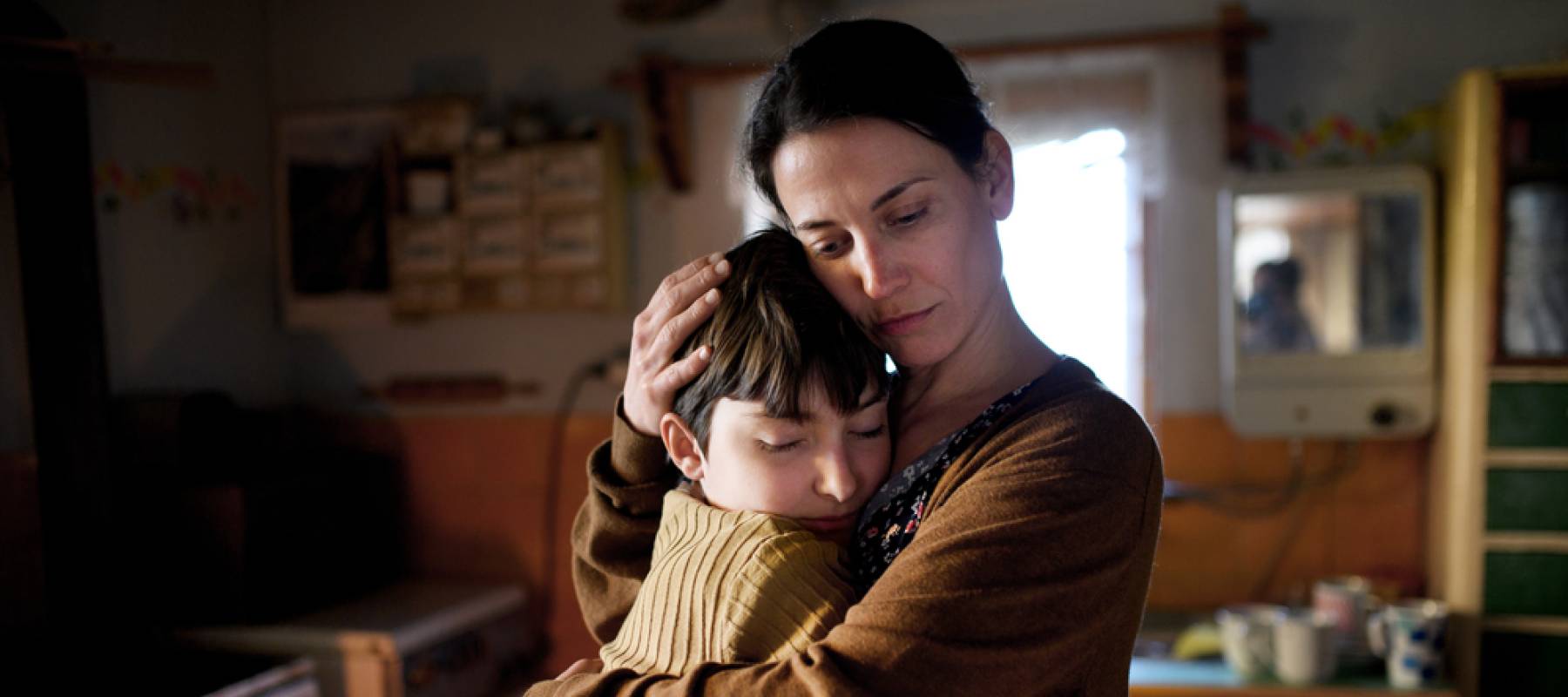 Portrait of sad poor mature mother hugging