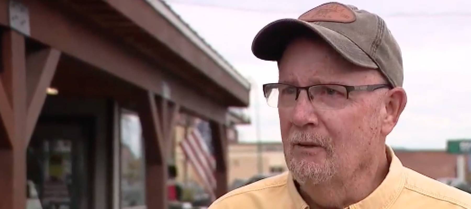 Man on street, speaking to reporter on camera.