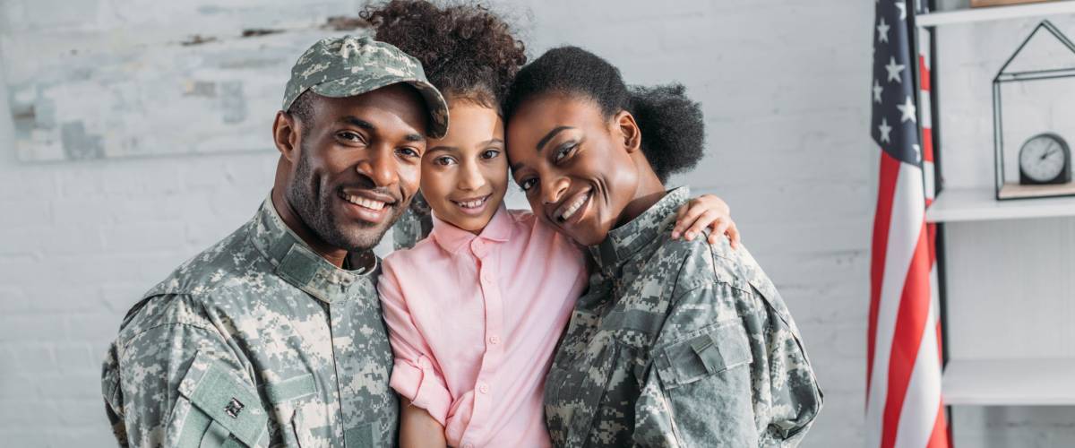 African american female and male soldiers embracing their daughter