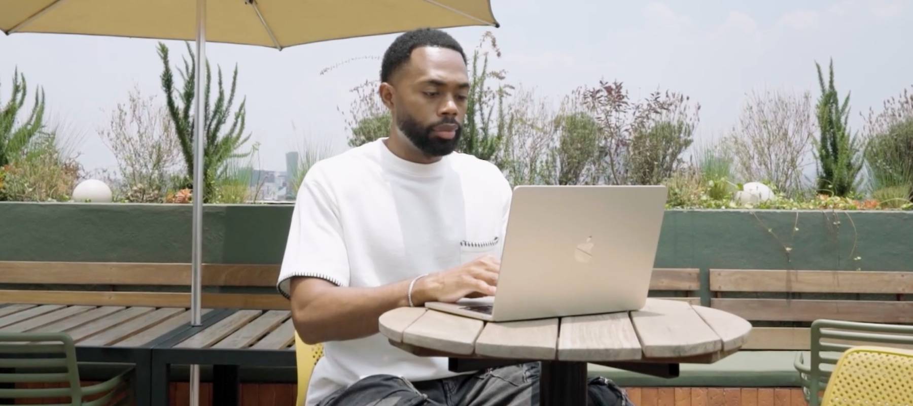 Derrick Morgan Jr. sits outside working remotely on a laptop on a patio in Mexico City.