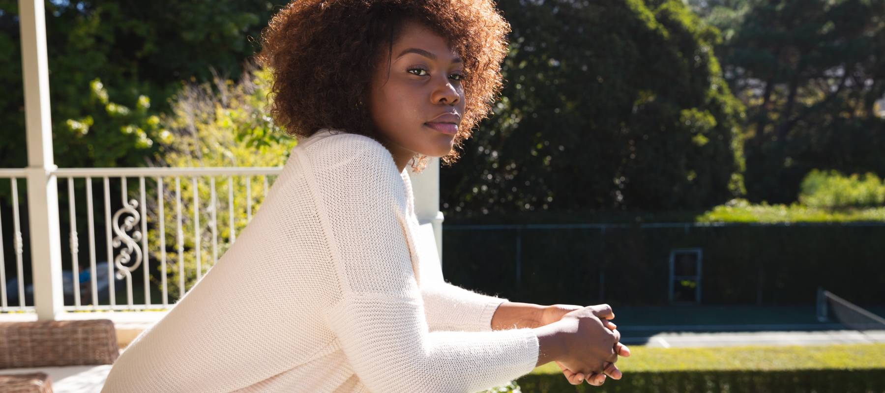 Woman relaxing on her sunny balcony.