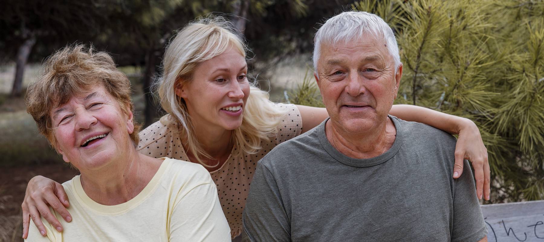 Woman standing between her aging parents.