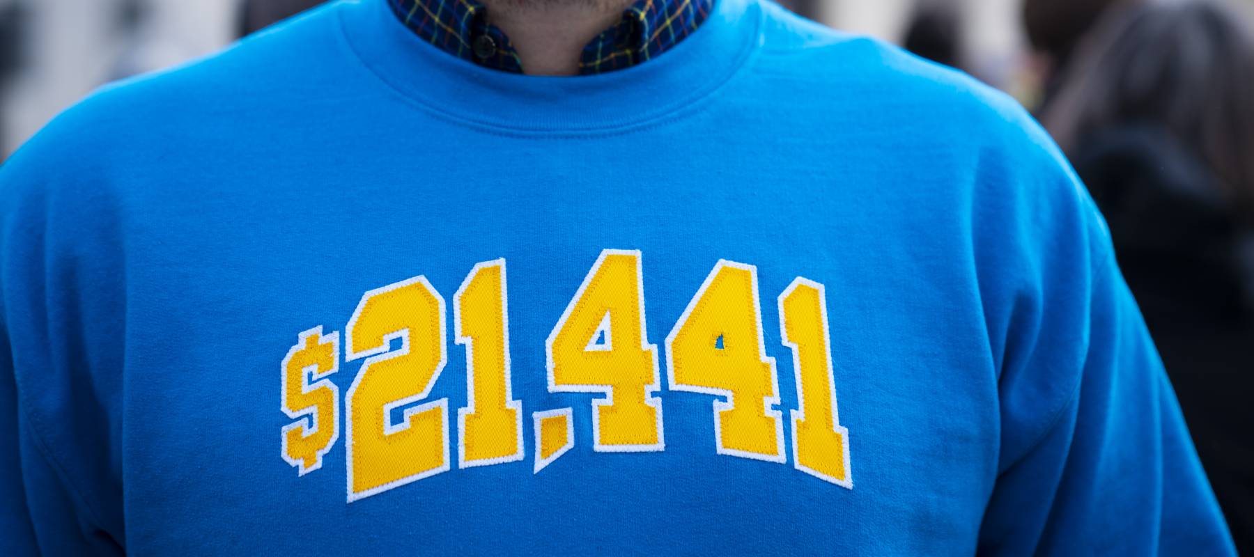 Cody Hounanian, executive director at the Student Debt Crisis Center, poses for a photo in a sweatshirt with the amount he owed in student loans.