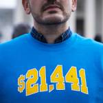 Cody Hounanian, executive director at the Student Debt Crisis Center, poses for a photo in a sweatshirt with the amount he owed in student loans.