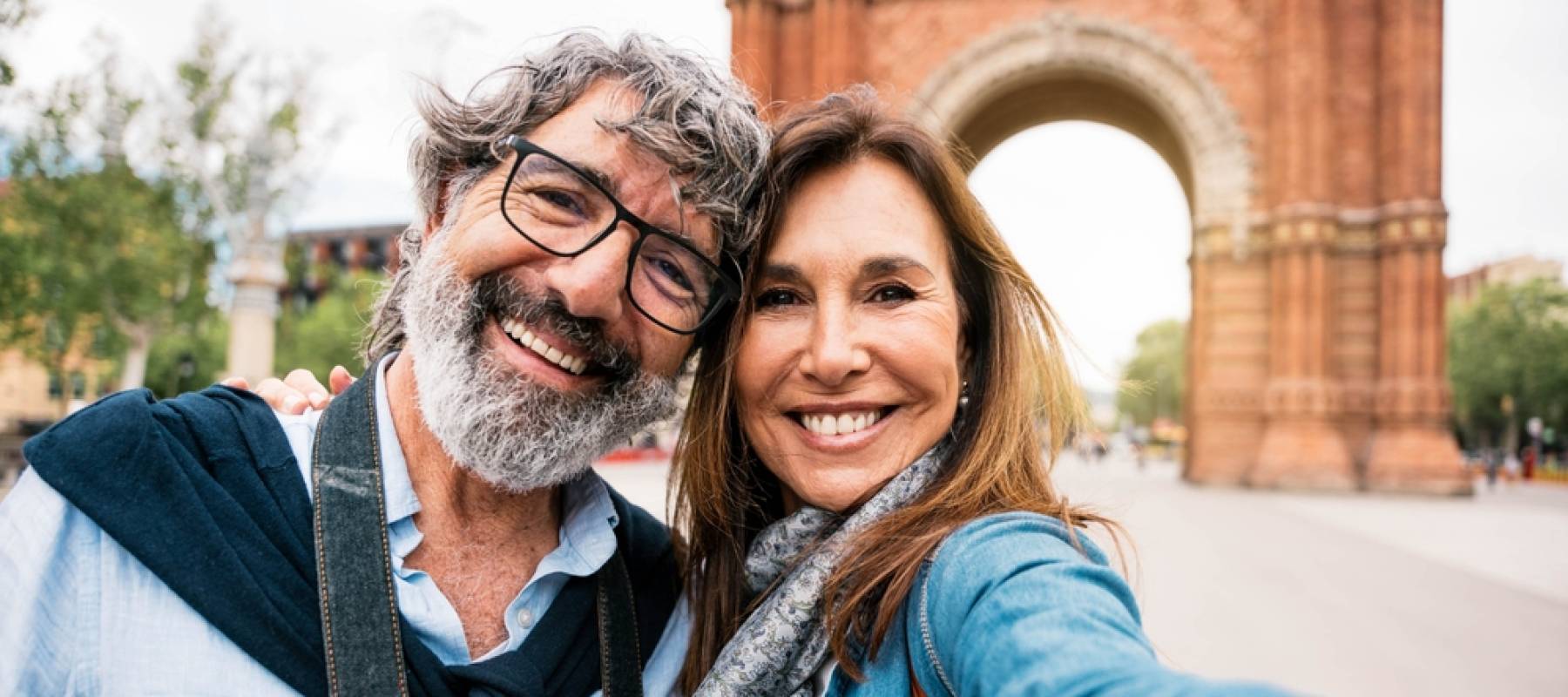 married couple taking selfie in front of Triumphal Arch in Barcelona