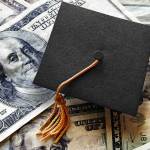 Miniature graduation cap on hundred dollar bills