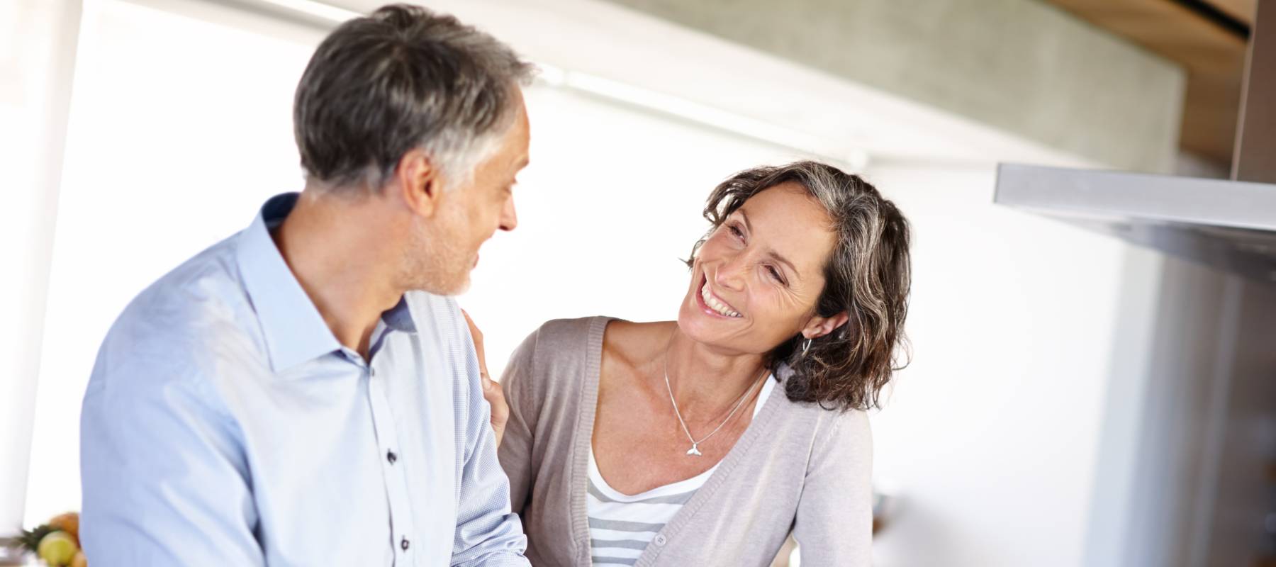 A couple share a moment in the kitchen.