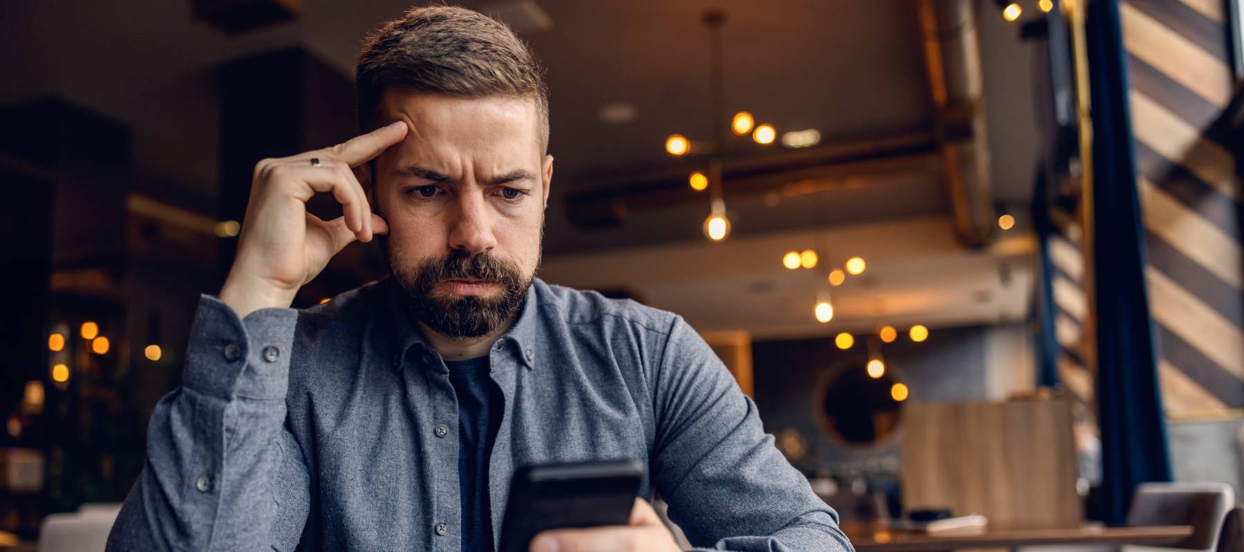 A worried man sitting in a cafeteria.