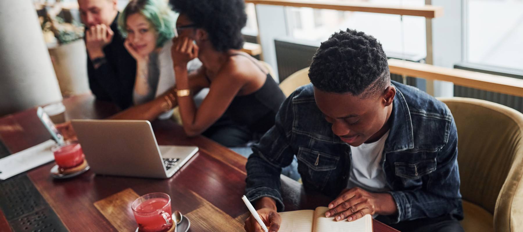 Black man sitting in front of group of multi ethnic people