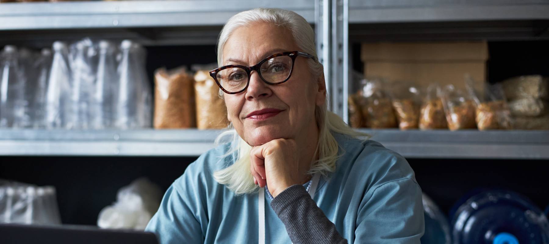 Portrait of woman working on laptop in warehouse.