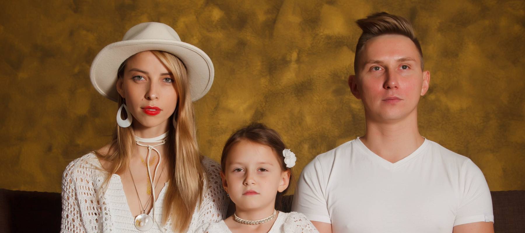 Serious young family sitting down.