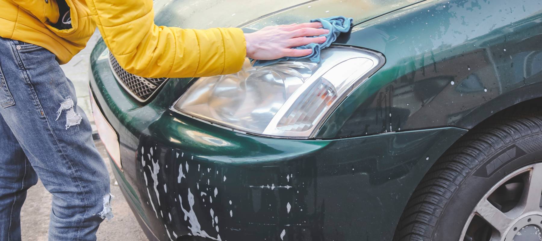 A young driver washes their car.