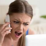 Angry dissatisfied young woman calling customer support or mobile banking, displeased client