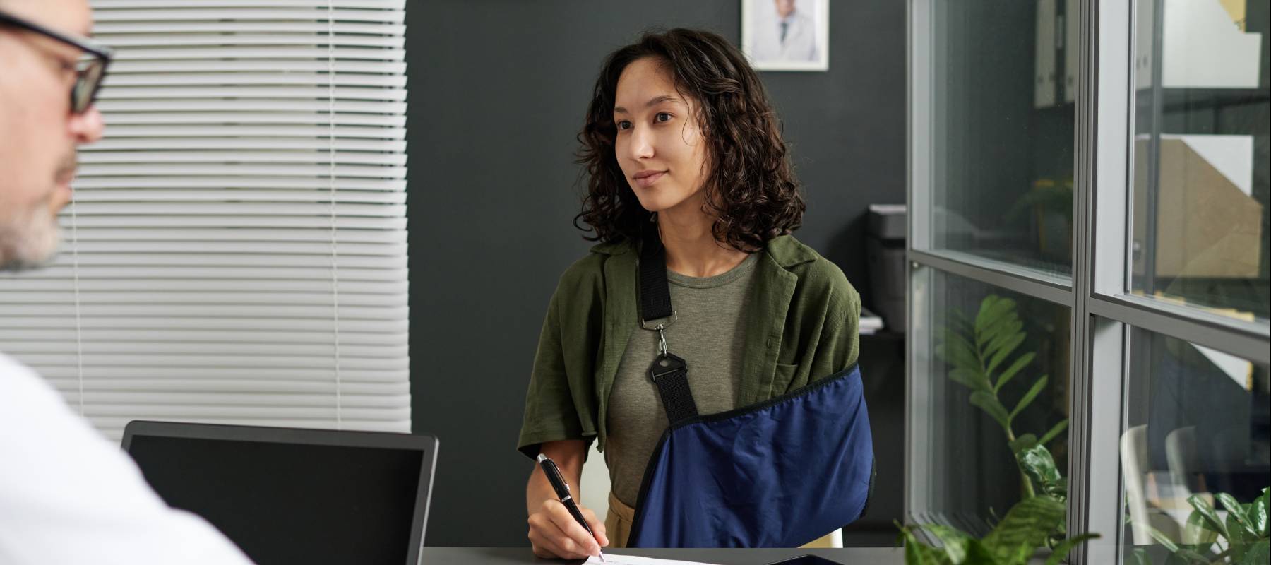 Young woman with arm injury in healthcare setting.