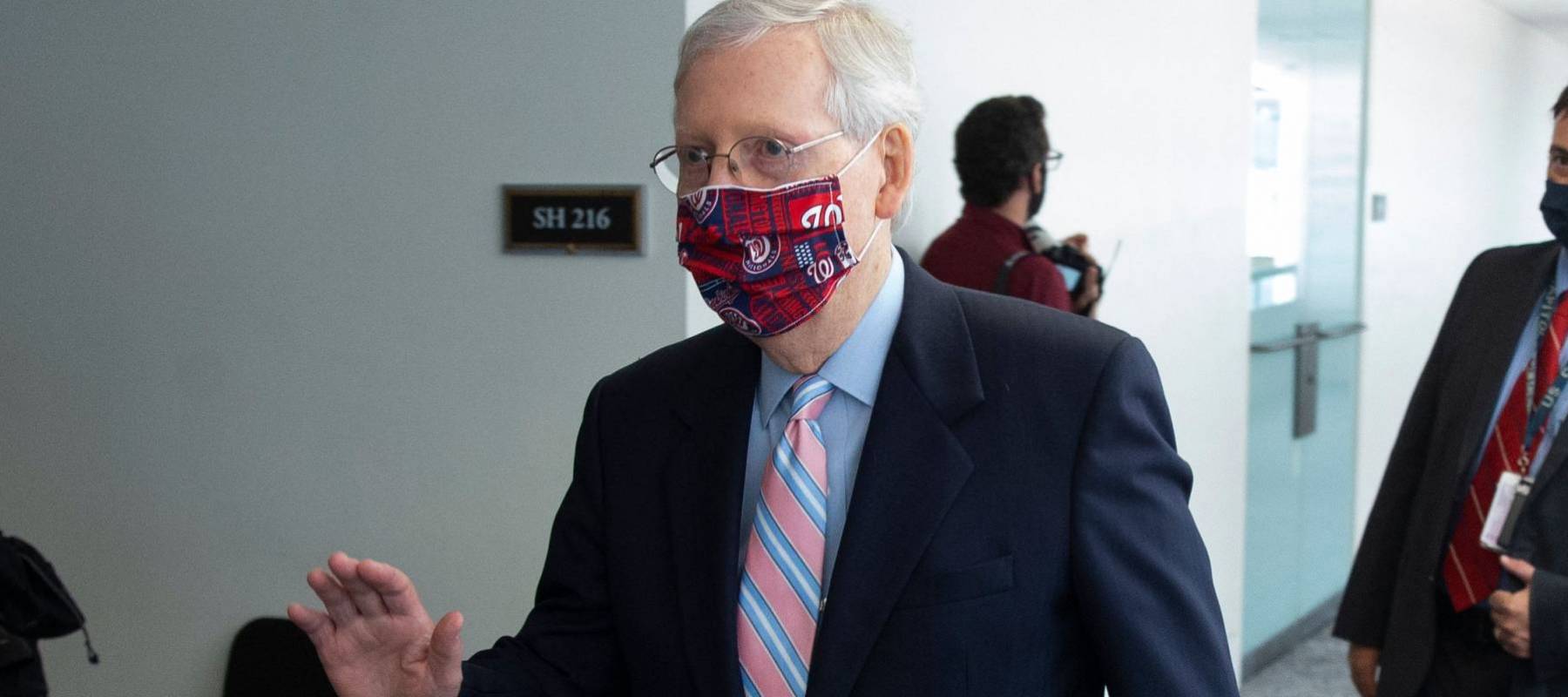 US Senate Majority Leader Mitch McConnell waves while walking to a Republican policy luncheon on Capitol Hill on July 28, 2020.