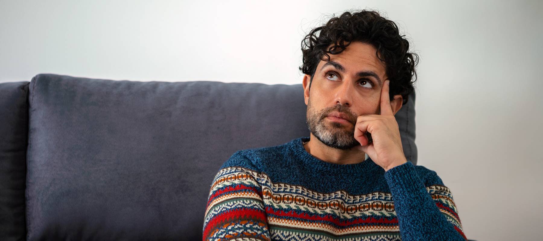 Portrait of handsome man wearing a winter sweater and thinking.