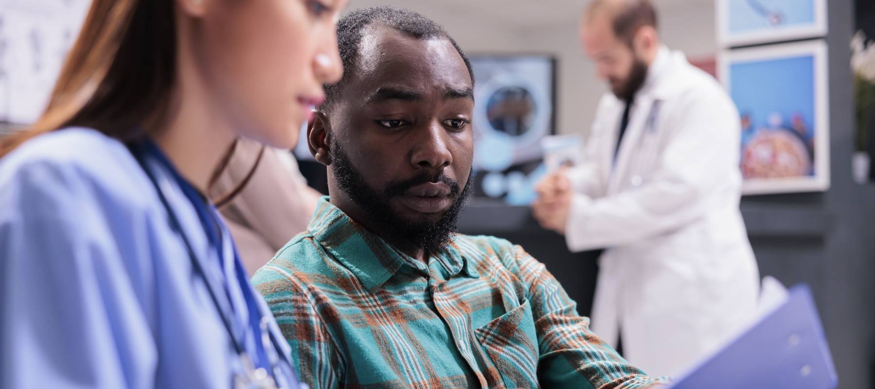 Close up of man reviewing medical records in a healthcare setting, looking concerned.