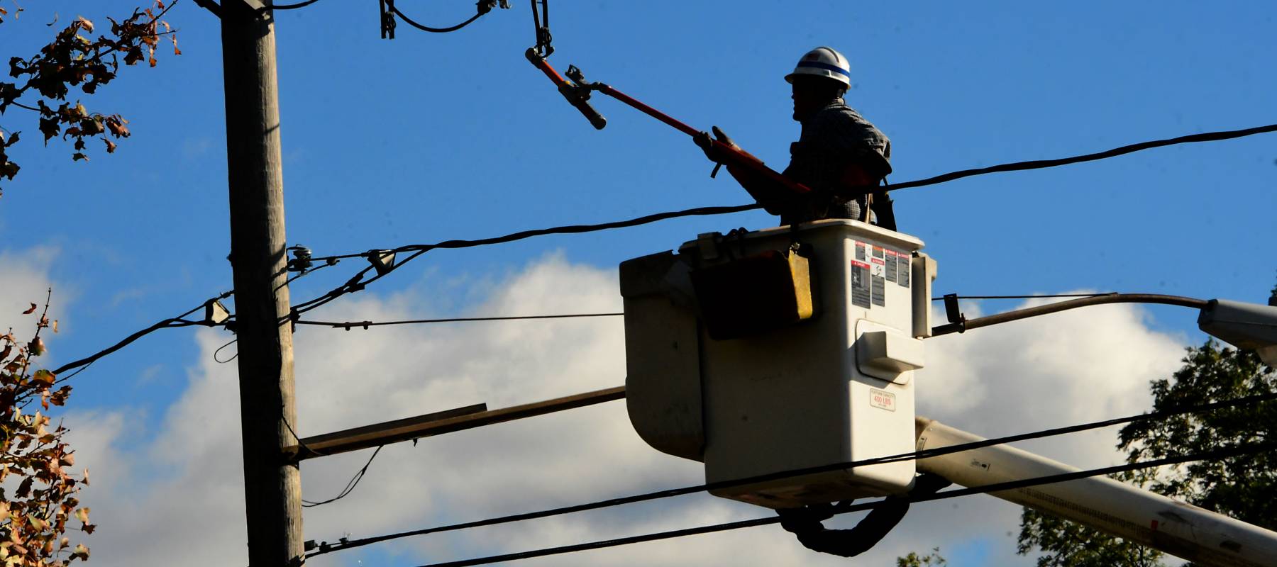 A National Grid lineman is seen working on a power line.
