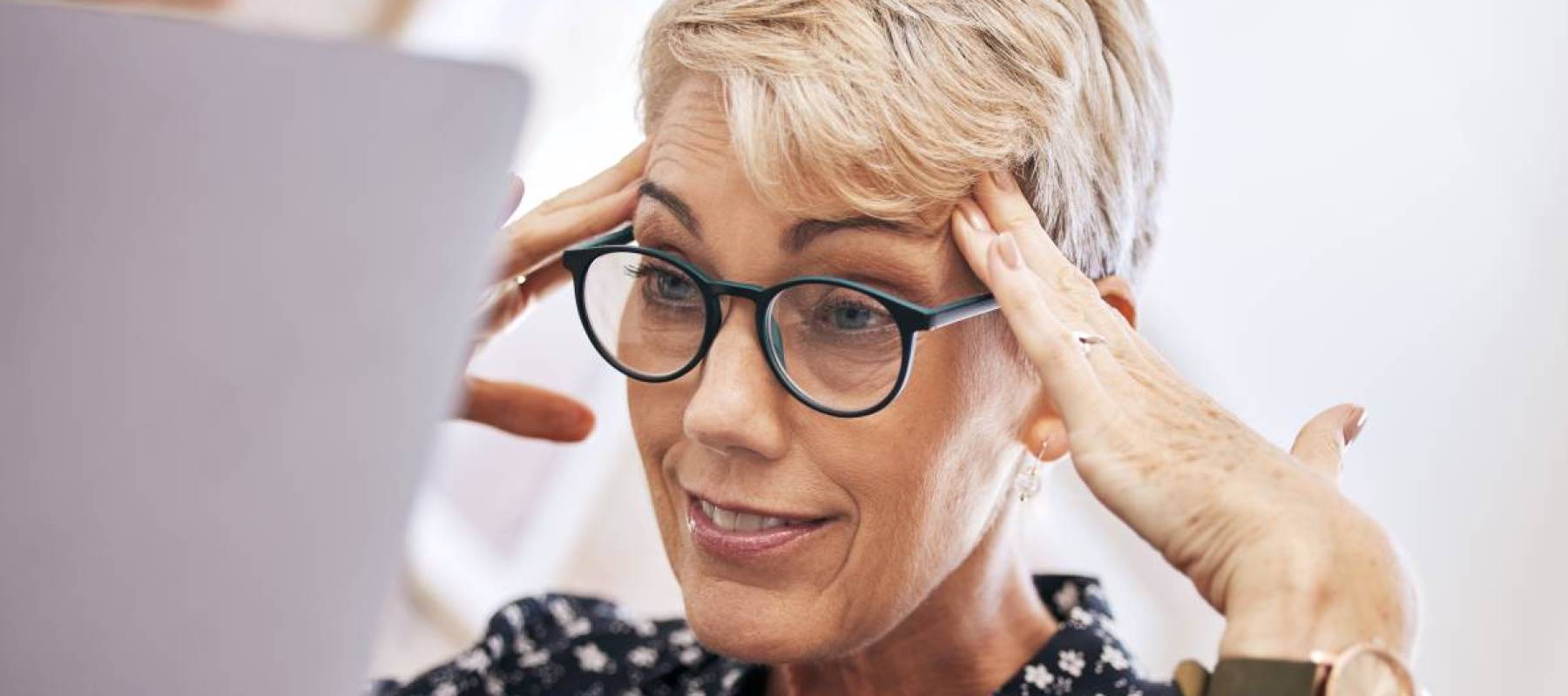 Shot of a woman sitting alone and feeling stressed while using her laptop to work from home.