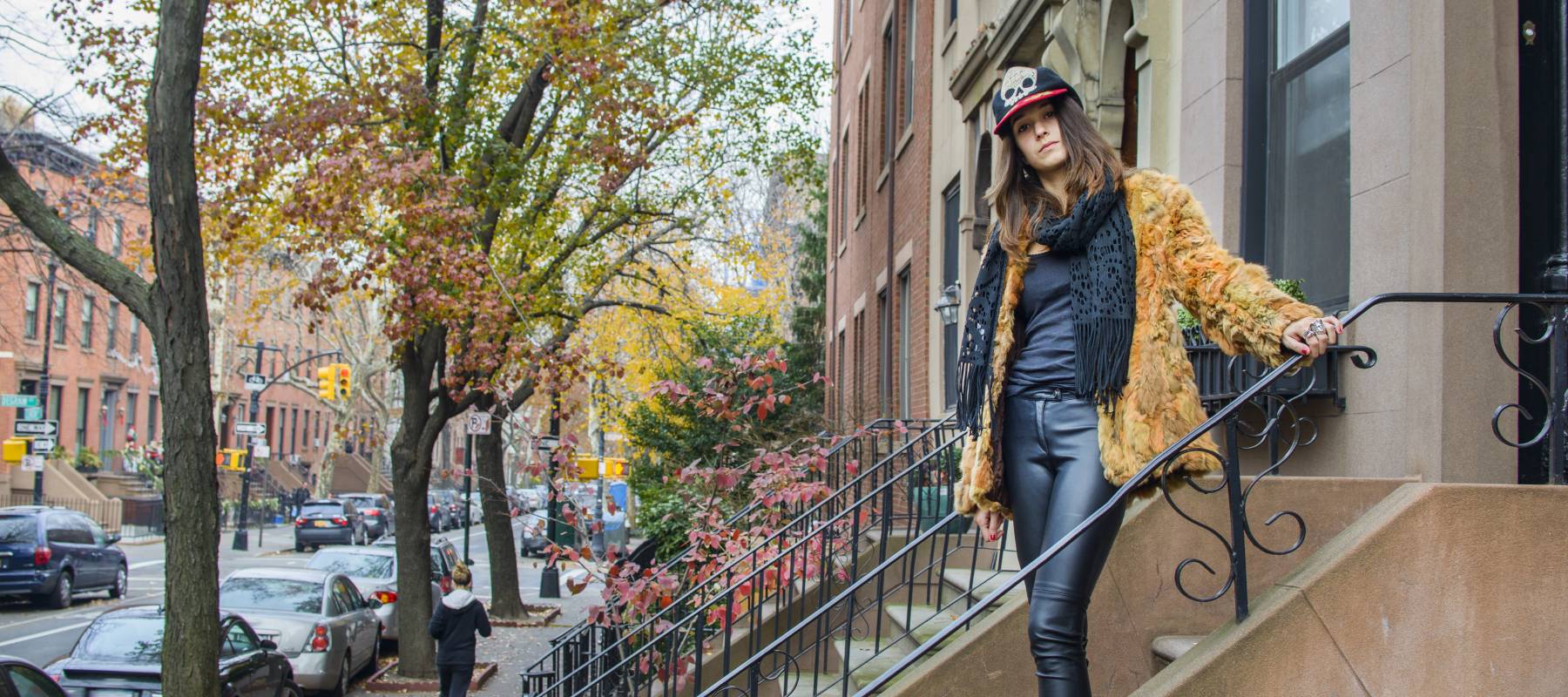 A young woman standing on the steps outside a home.