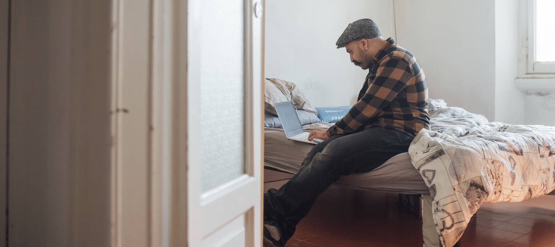 Man reading intently in a cozy bedroom.