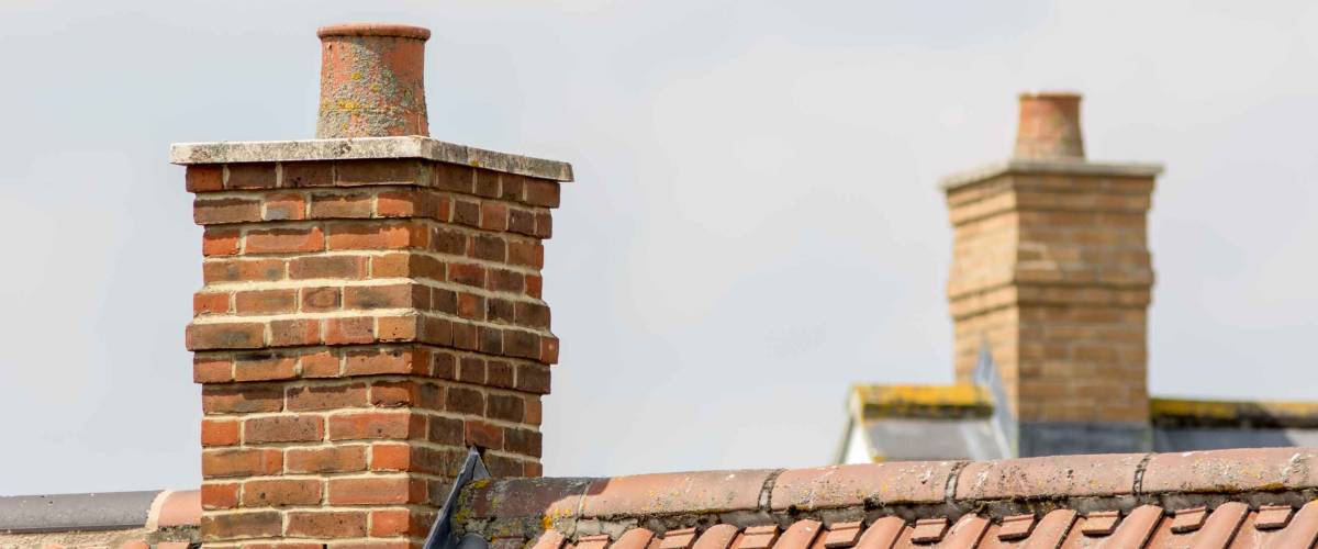 Brick chimney stack on modern contemporary house roof top.