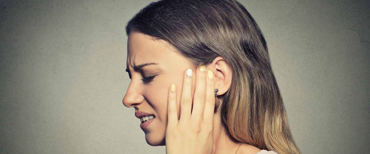 Woman in pain, touching her ear