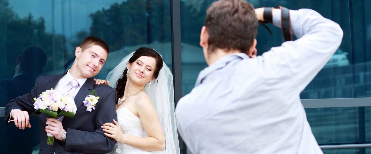 Wedding photographer in action, taking a picture of the bride and groom