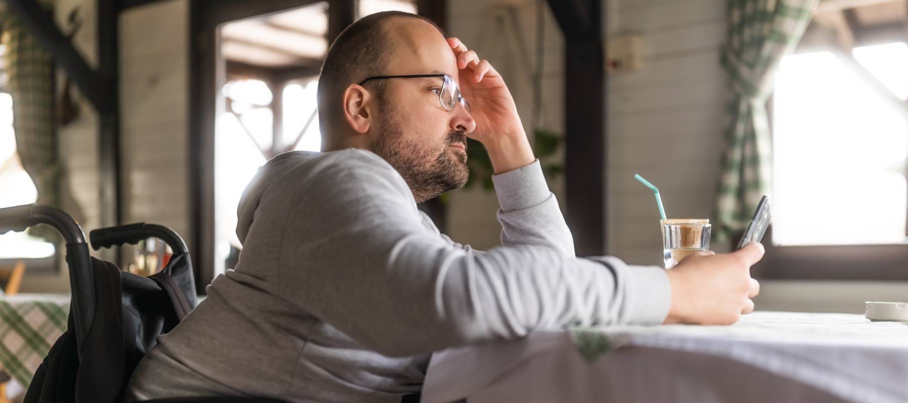 Man using a wheelchair alone at a cafe.