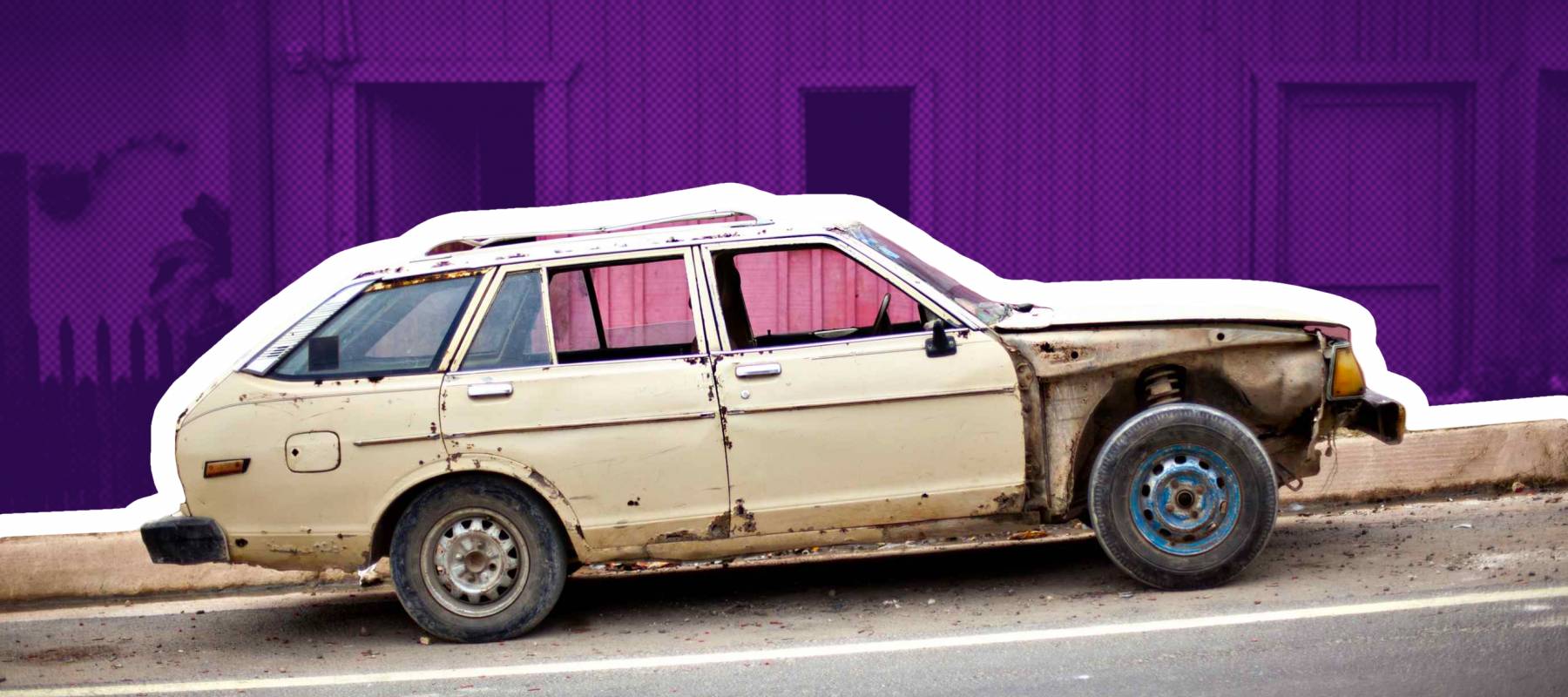 old car in front of pink building