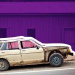 old car in front of pink building