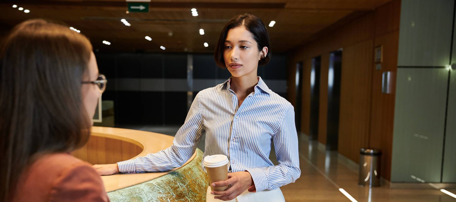 Colleagues chatting in office lobby.