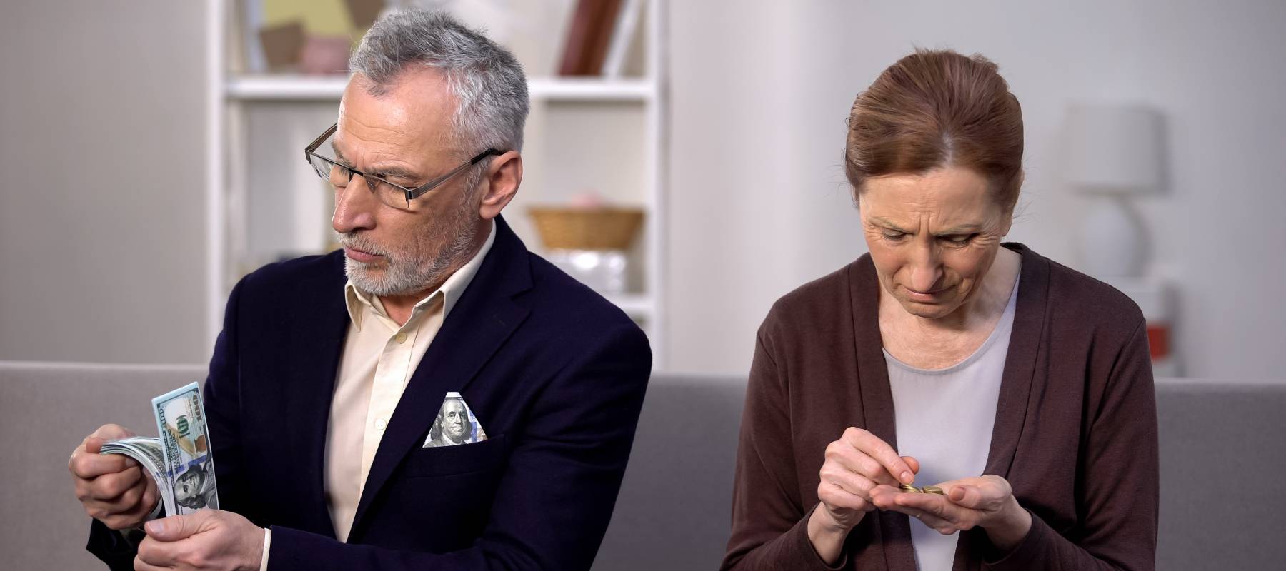 Older couple counting bills and pinching pennies.