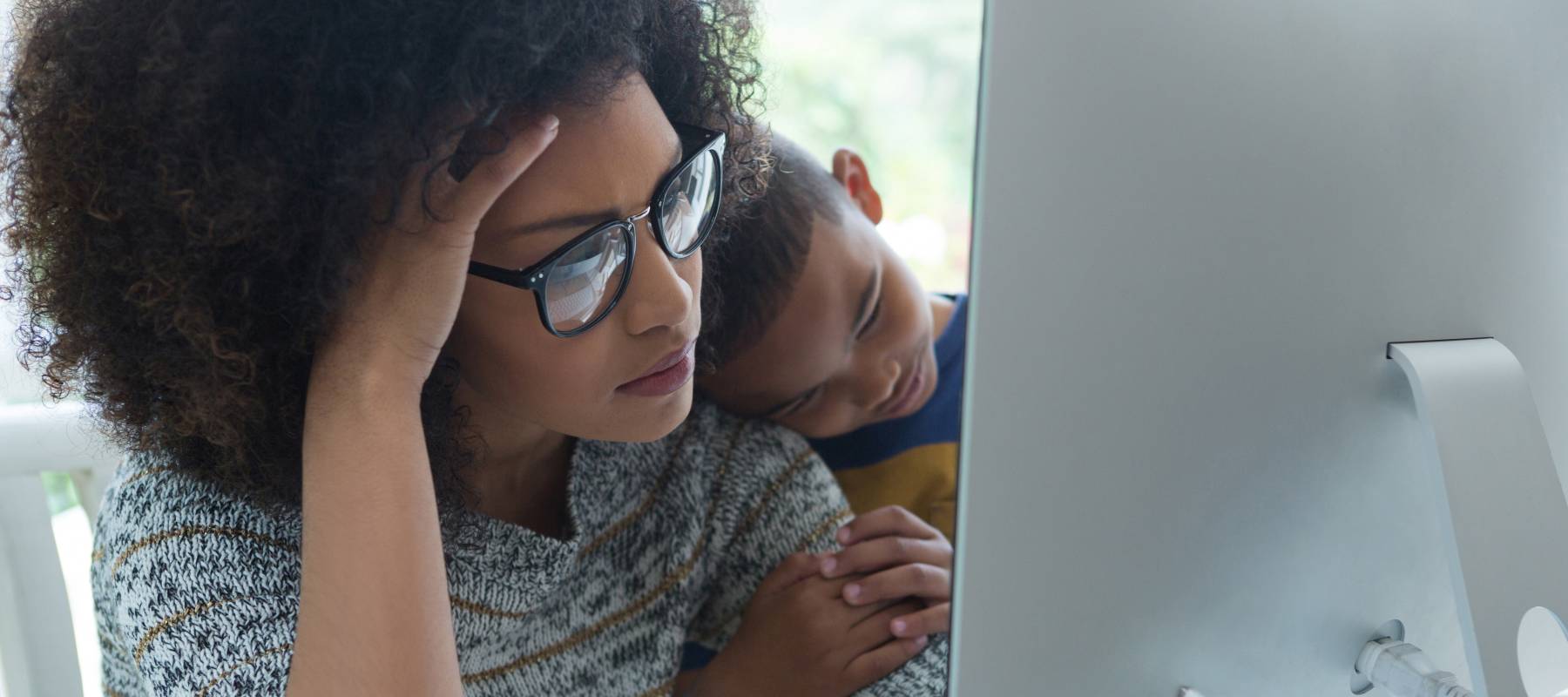 Woman and young boy looking at a computer screen.