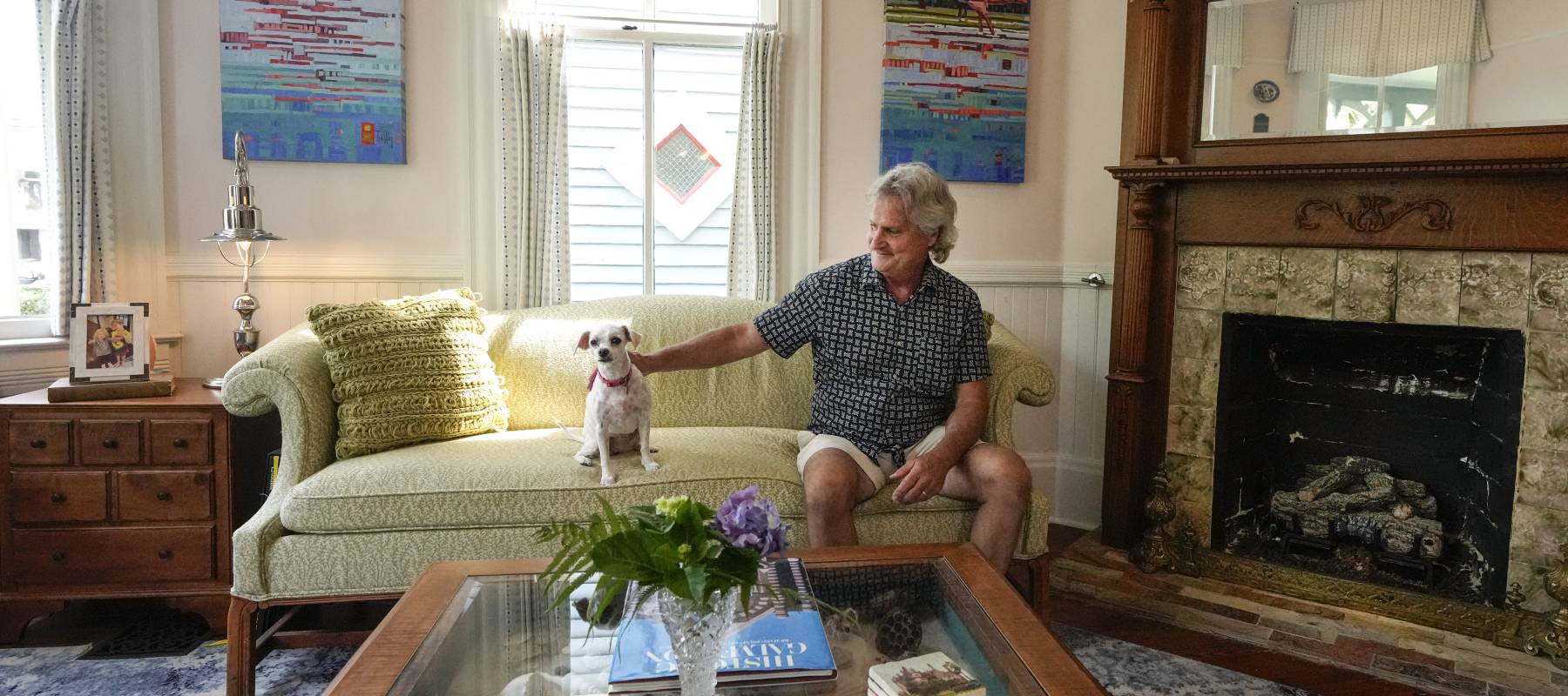 Greg Stickline pets his dog, Gretel, as he sits in the living room of his home, that is up for sale.