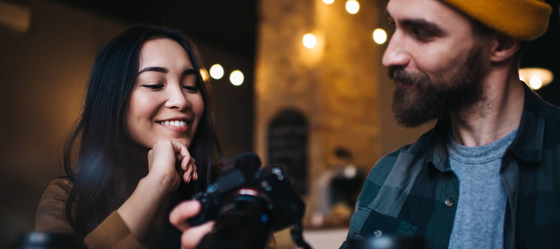 A man showing a camera to.a woman.
