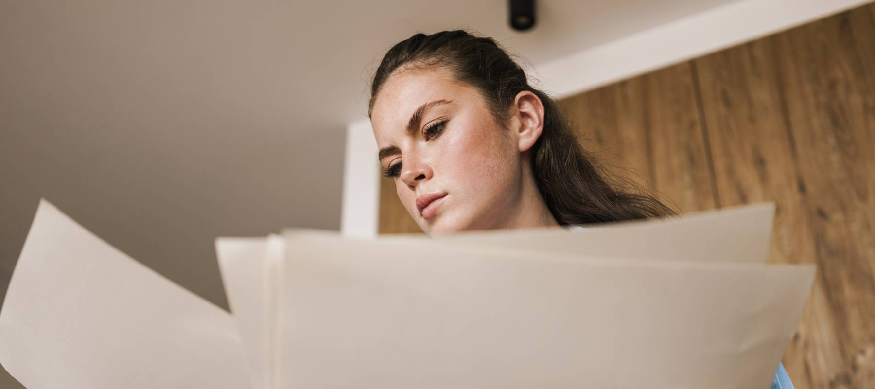 Woman reviewing paperwork with a worried expression.