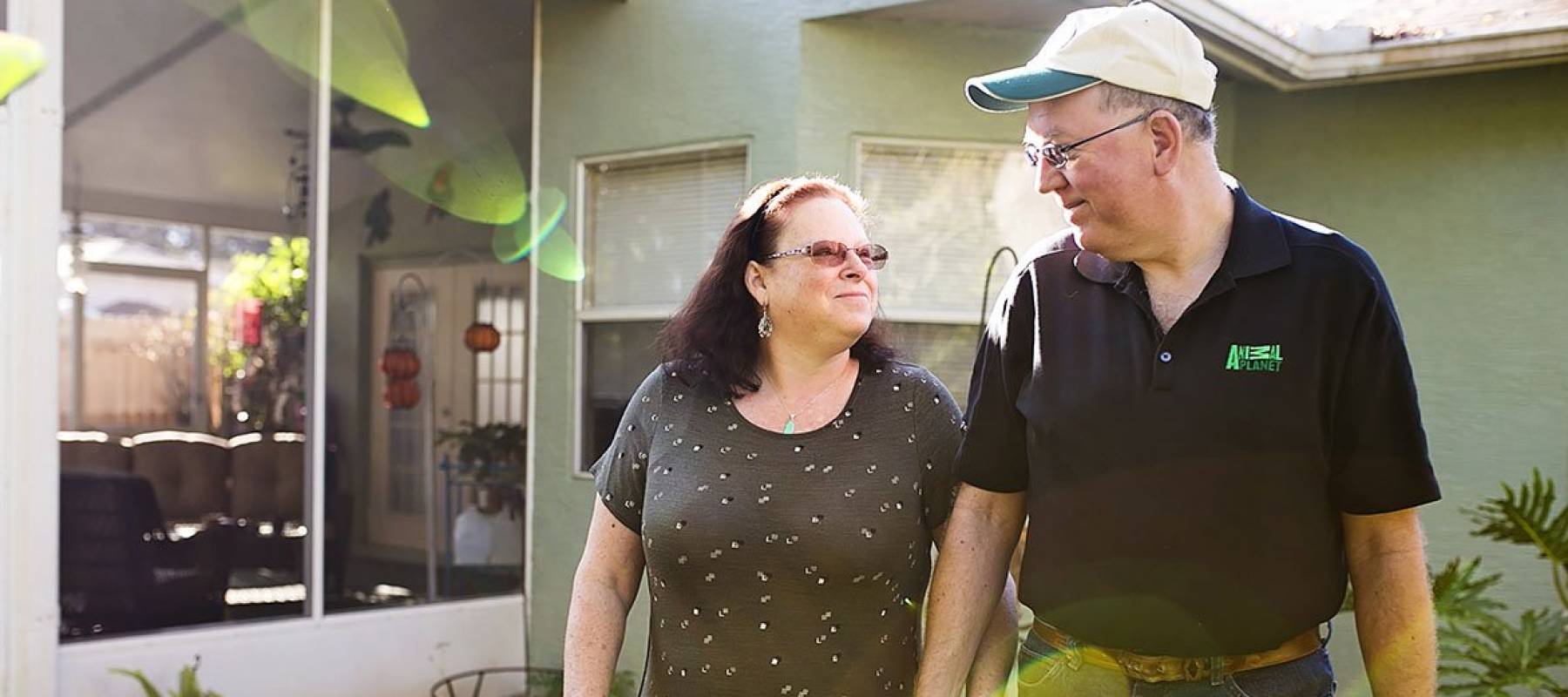 Middle aged couple eyeing each other fondly as they walk through a garden