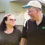 Middle aged couple eyeing each other fondly as they walk through a garden