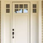 White front door with small square decorative windows and flower pots