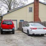 Cars parked along a suburban street with lawns and trees