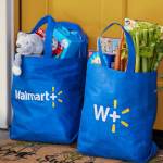 Two Walmart+ reusable shopping bags outside the front door of an attractive home