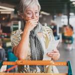 Woman looking with shock at grocery receipt.