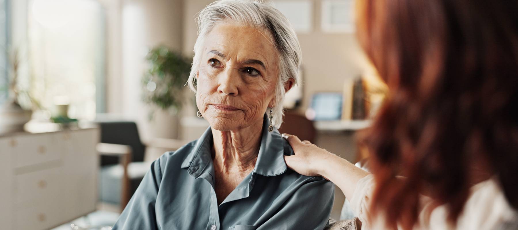 A young woman speaks with an older woman.