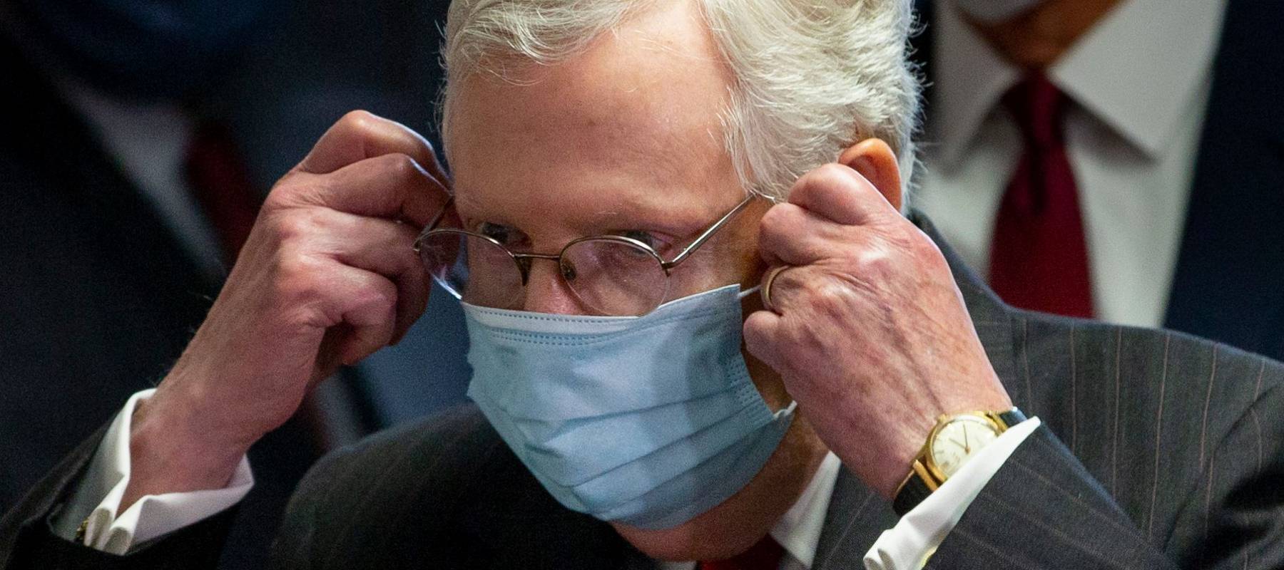 Senate Majority Leader Mitch McConnell takes off a face mask before a news conference in Washington, D.C., on May 5, 2020.