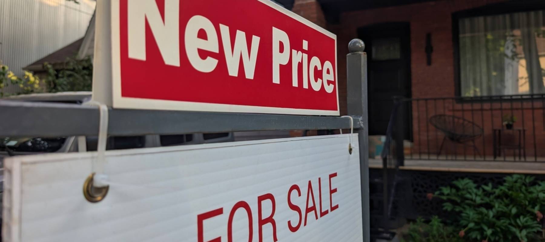 A For Sale sign with a New Price marker