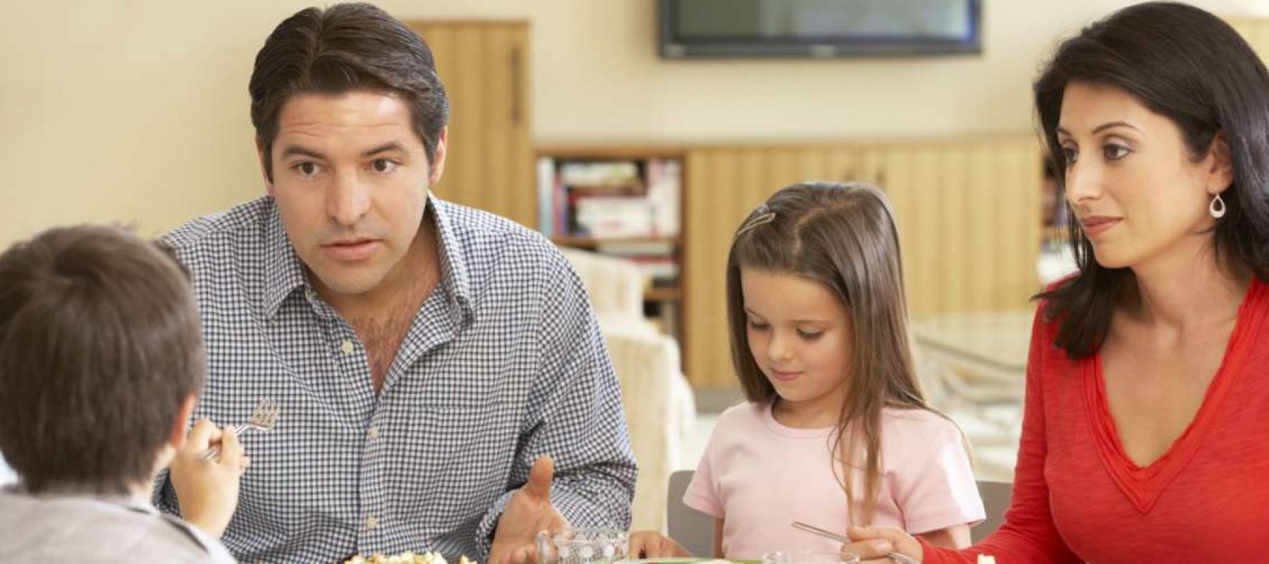Young family enjoying a meal at home and having a conversation