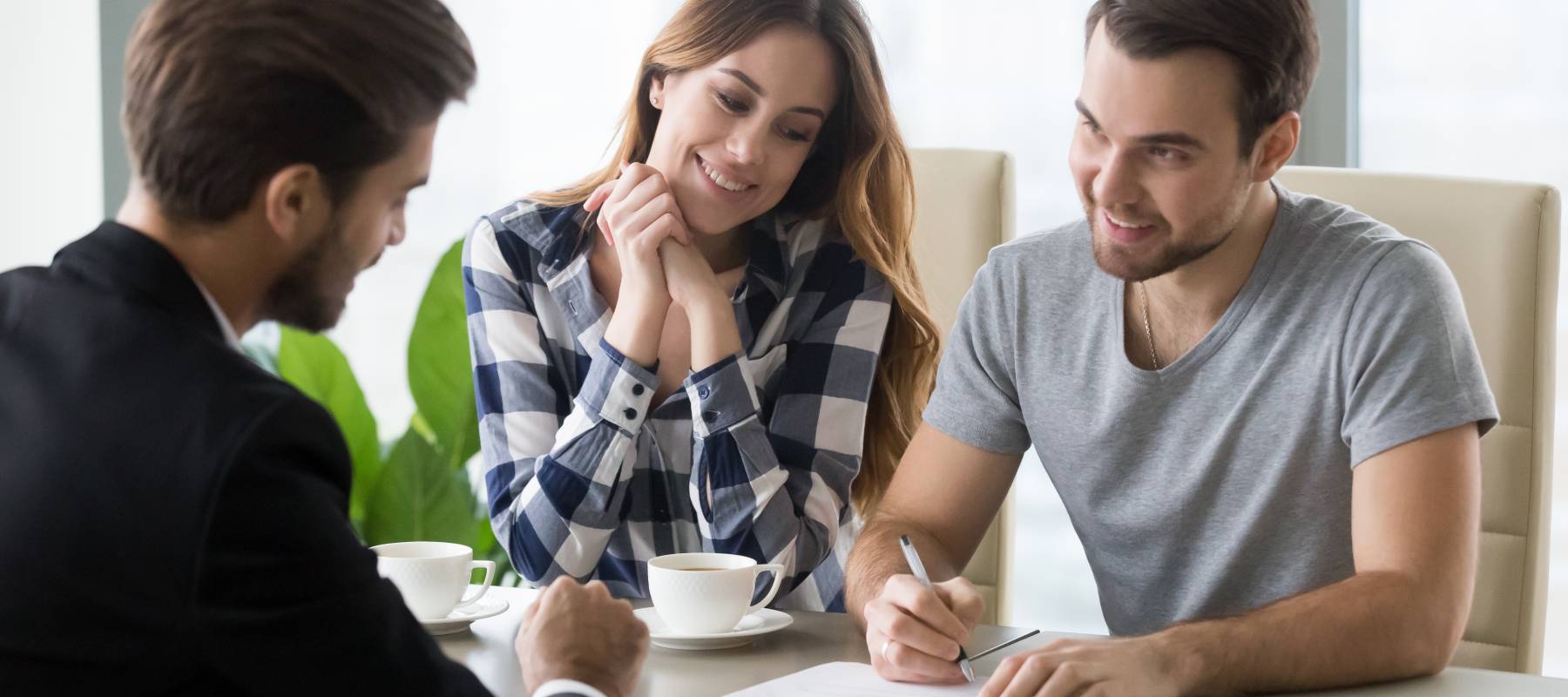 Young couple signs personal loan contract with banker